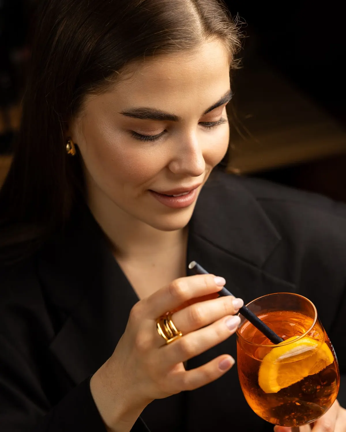 Aperol Spritz with an orange slice in hand