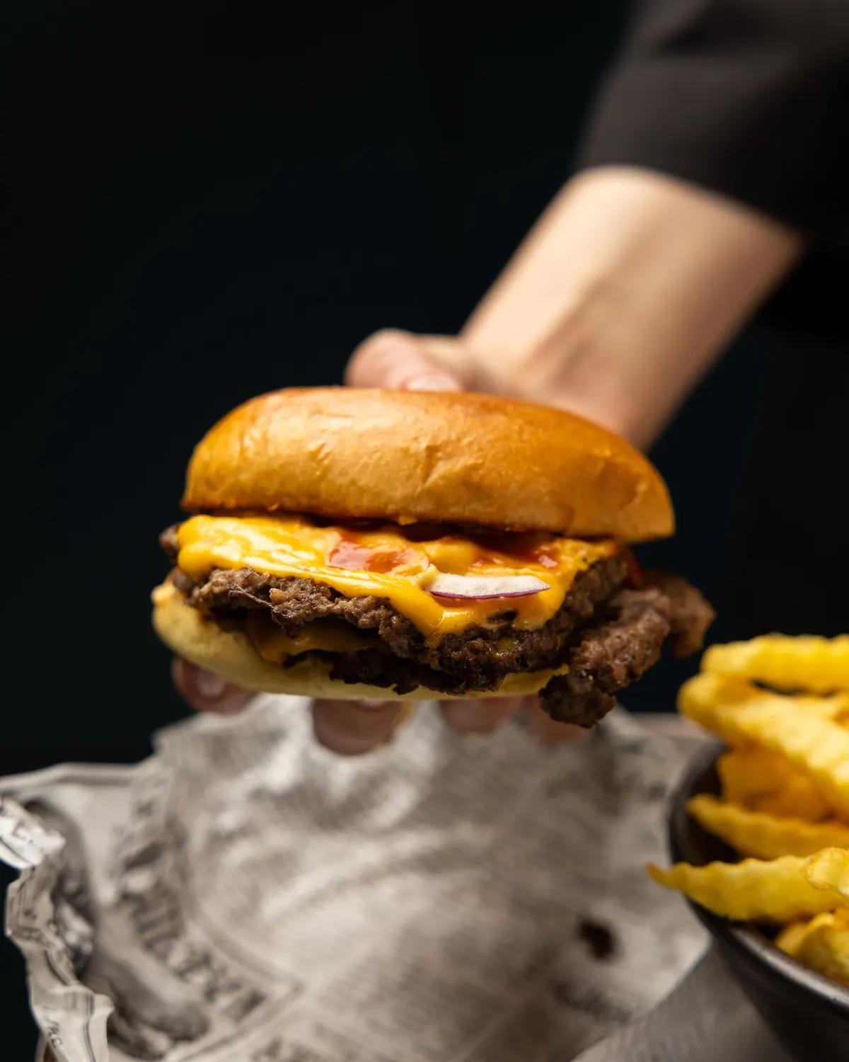 Cheeseburger in der Hand